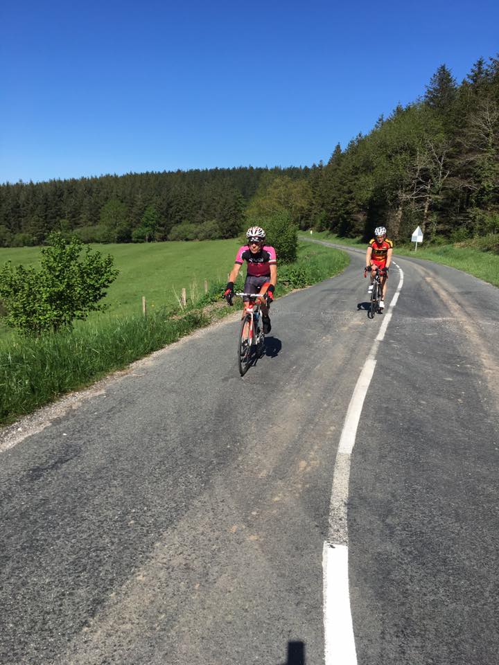 Deux cyclistes du BOC sur une route forestière sous un grand ciel bleu