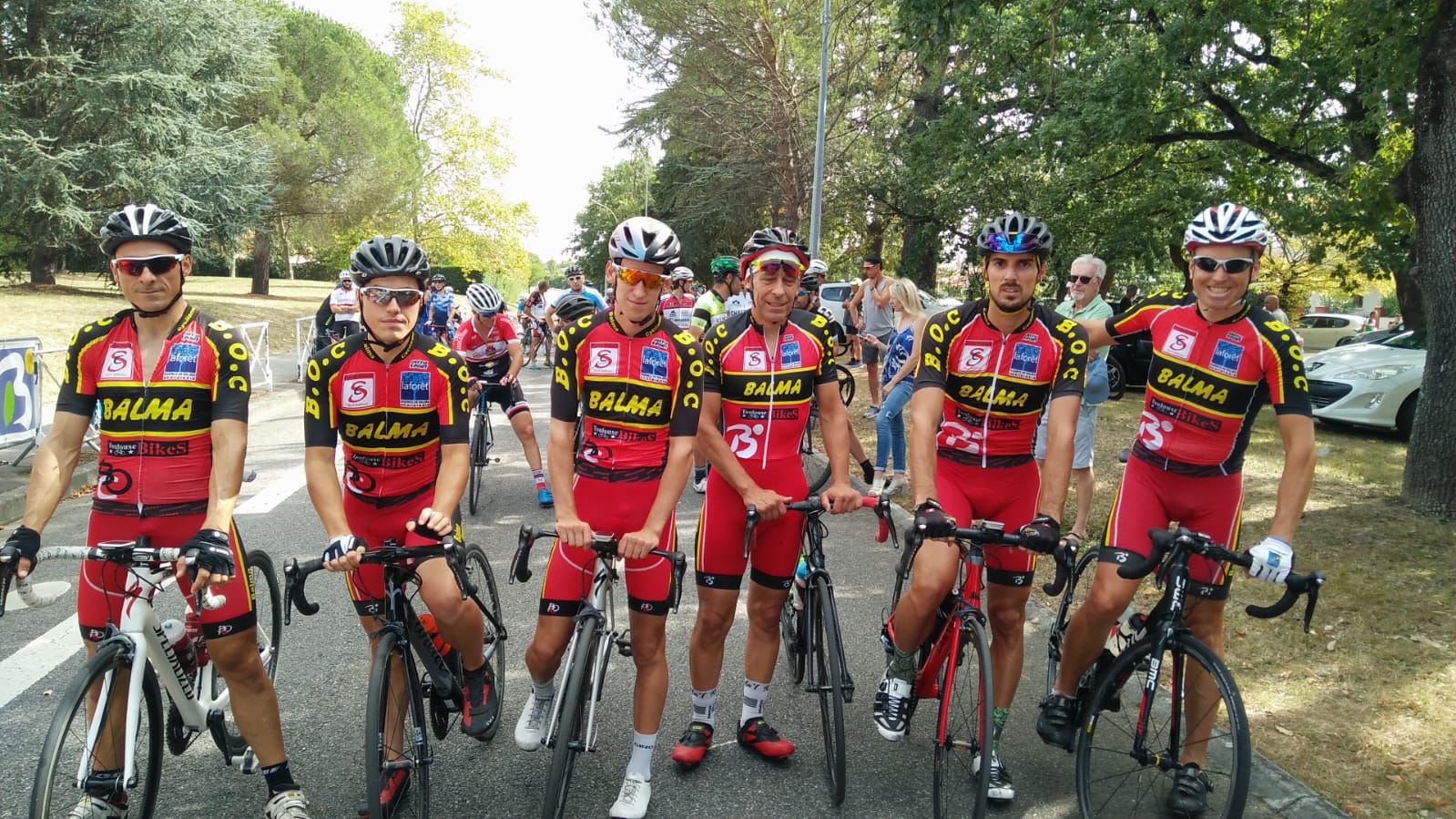 Six coureurs du BOC en maillot rouge et noir posant avant le départ d'une course à Balma